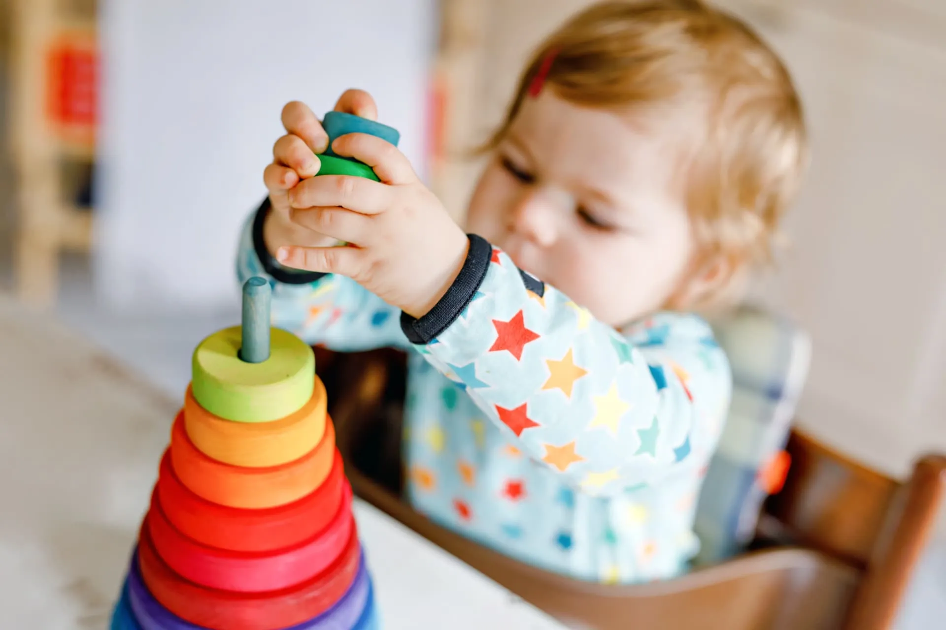 Criança pequena empilhando brinquedos coloridos